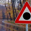 Red triangle road sign with a black dot: meaning and where to see it
